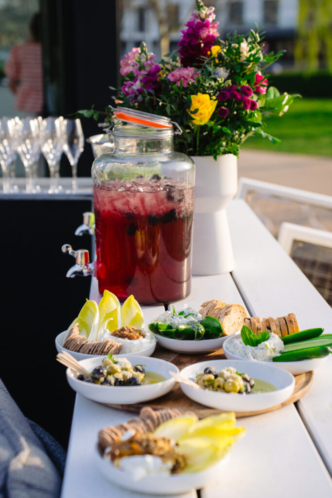 Drankentafel met bloemen en hapjes op het terras
