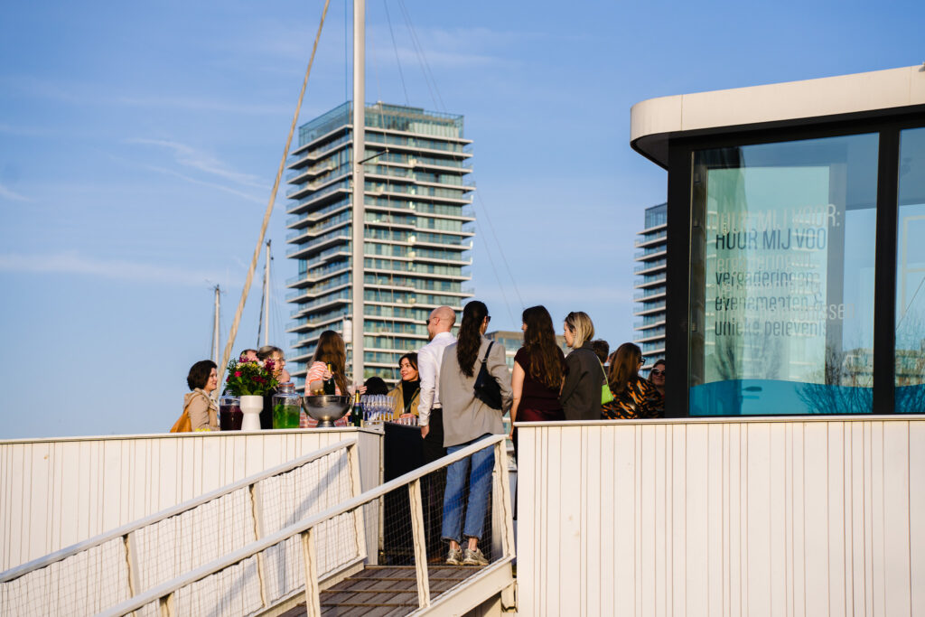 Gasten op het dek van Meet Puert'O bij zonsondergang